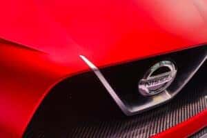 The front of a red Nissan showcasing the logo