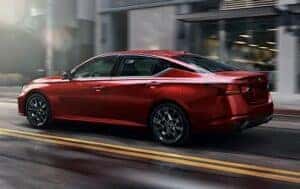 2023 Nissan Altima in Red driving on a city street