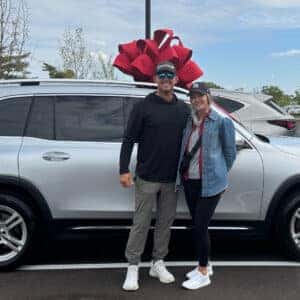 couple in front of new suv with a bow on it