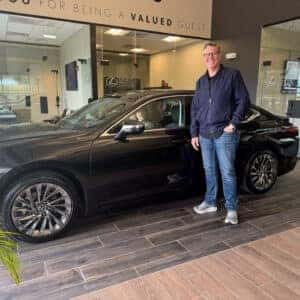 man in front of new car
