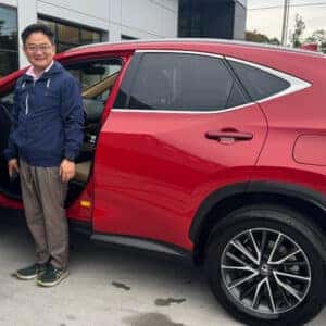 man standing at front of red car door