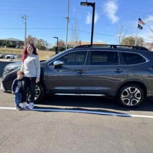 woman with child standing in front of suv