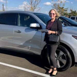 woman standing at the front of SUV