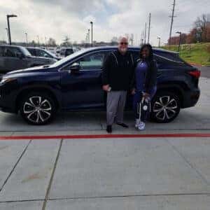couple standing to the side of SUV