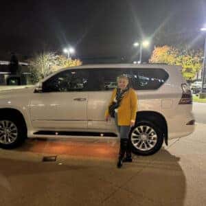 Woman with yellow jacket standing next to SUV