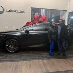 Couple in Showroom standing in front of new car