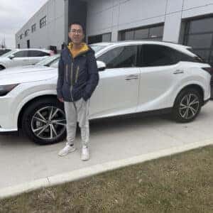 Man with Yellow/Gray Jack in Front of New Car