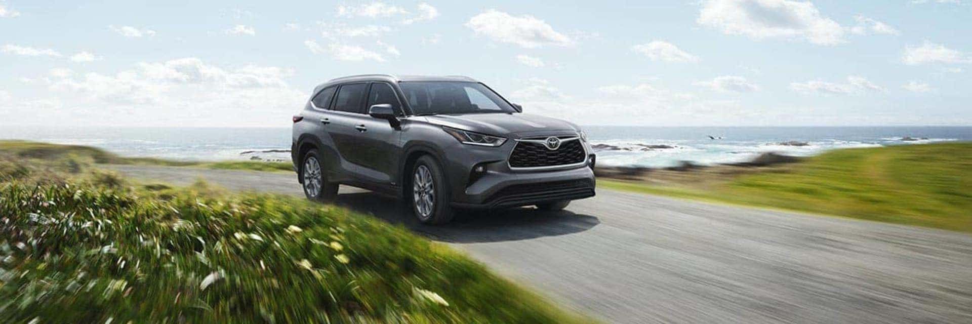 2025 toyota highlander driving down a road