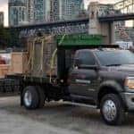 2022 ram chassis cab truck parked by a dock with loaded equipment in the back with workers walking towards the truck