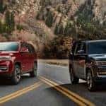 comparison image of a red 2022 jeep wagoneer versus a black 2022 jeep grand wagoneer on the road