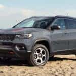 A gray 2022 Jeep Compass sits parked on the beach.