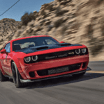 A Red Dodge Challenger zooms down the highway in a dessert. Image demonstrates why some might ask "Why is Dodge Discontinuing the Charger and Challenger?"