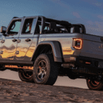 A Jeep Pickup Gladiator sits parked on an incline at sunset.