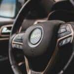 Close up view of a steering wheel on the interior of a 2023 Jeep Cherokee.