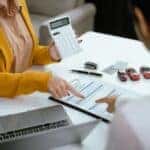 female working with calculator for car payment