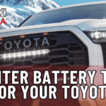 Close-up of a Toyota Tundra with a snowy mountain in the background, highlighting its rugged design and readiness for winter driving in Ohio