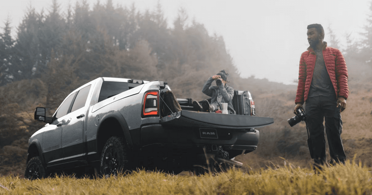 Photographers around the bed of a 2024 Ram 2500 in the woods