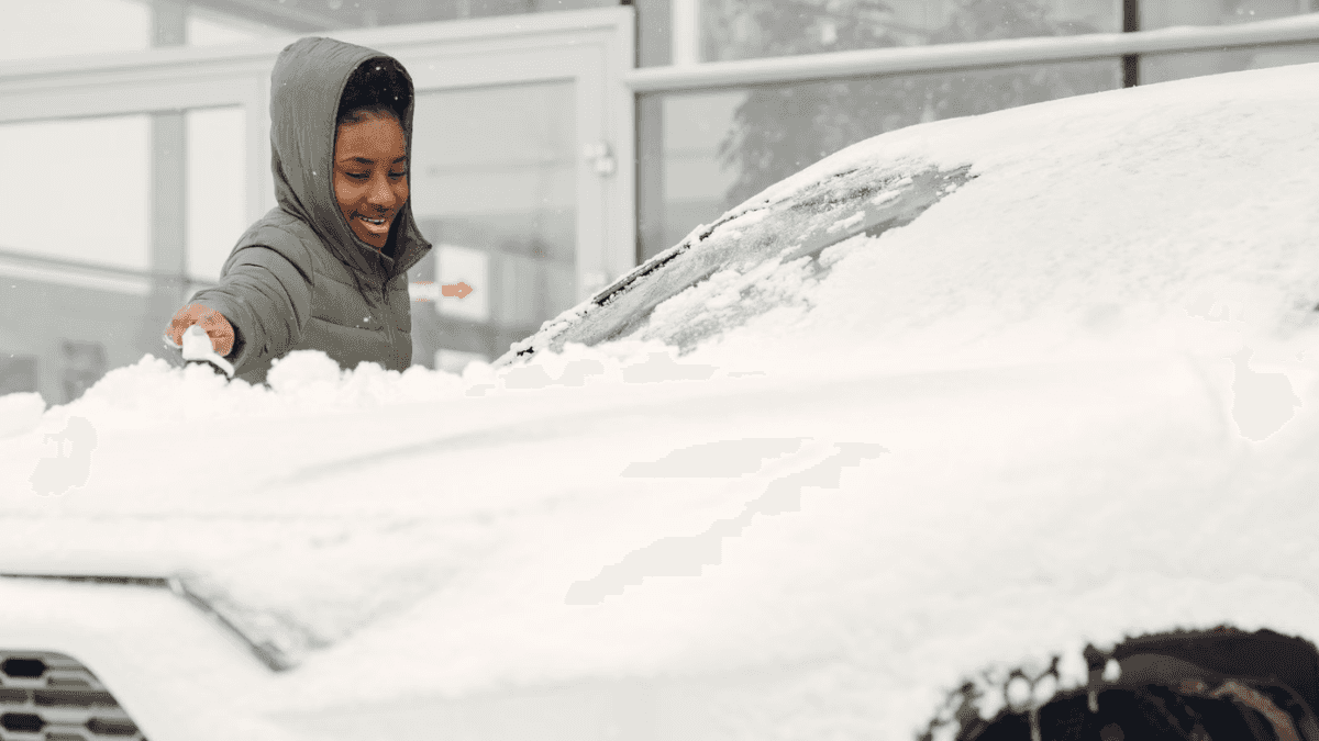 girl scraping snow off a pre-owned SUV for sale near Buffalo, NY