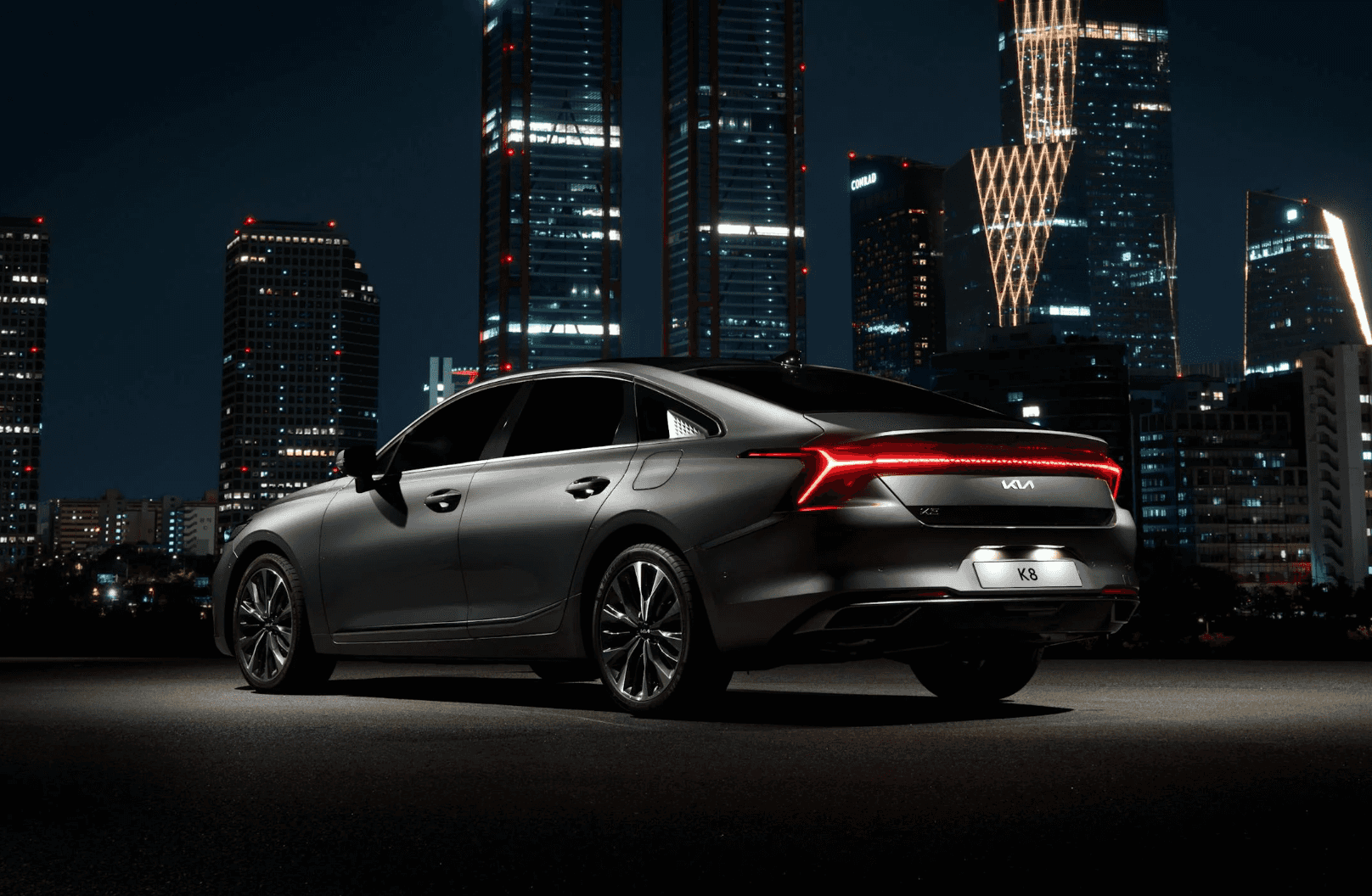 Black Kia in front of a city skyline 