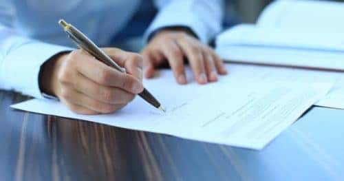 man writing on paper
