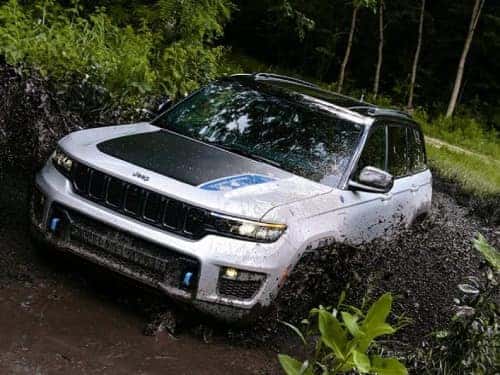 2024 Jeep Grand Cherokee 4xe driving through muddy area