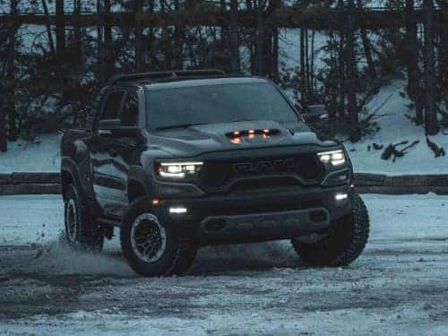 2024 RAM 1500 TRX offroading in the snow at night with headlights on