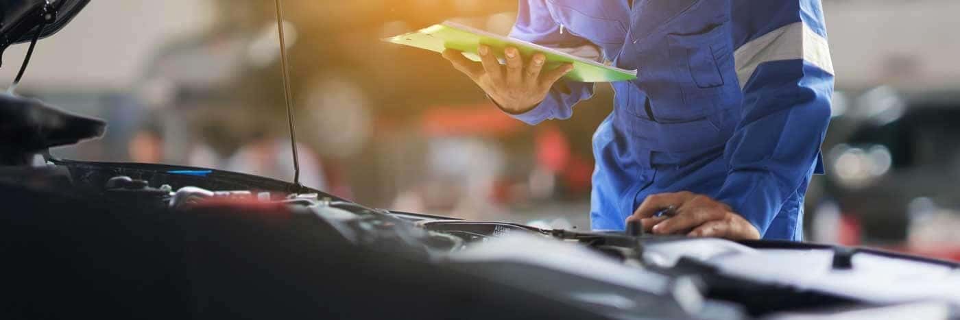 Close up view of a service tech looking at a vehicle's starter