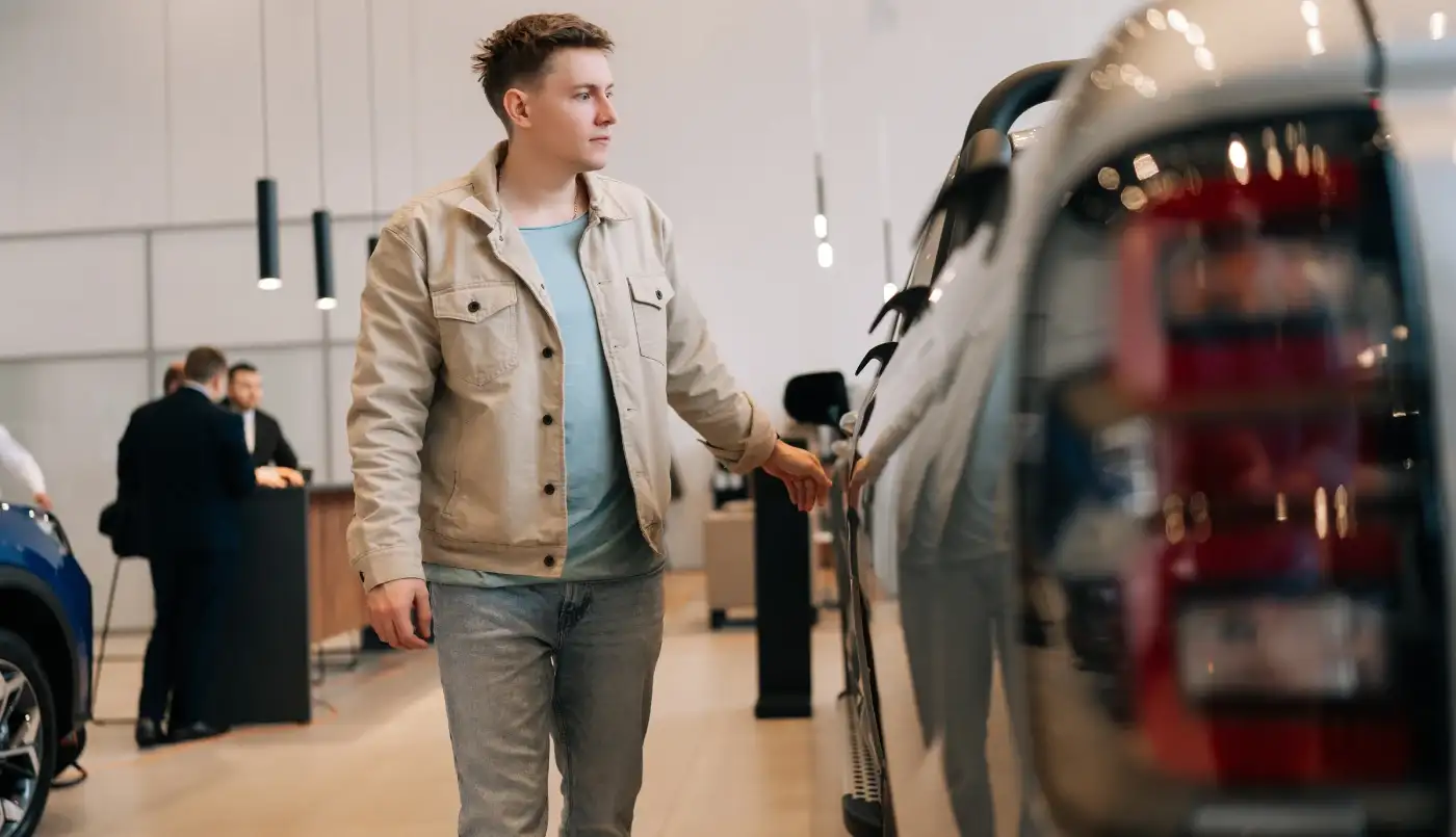 Young man looks at pickup truck in new invent