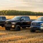 Chevy, RAM and Ford trucks next to each other in a field