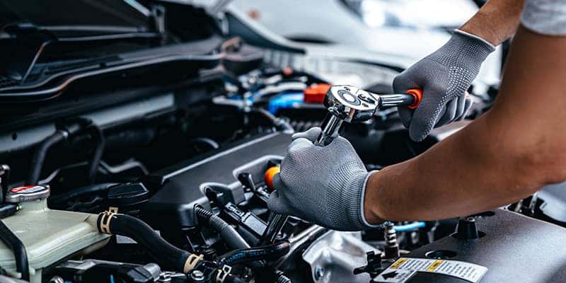 MOPAR mechanic changing spark plugs on a RAM 1500 pickup truck